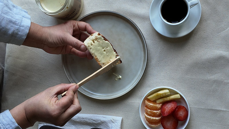 Desayuno visto desde arriba: tostada con miel cremada Valymu, café y fruta